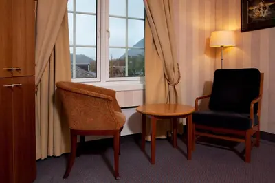 a room with two chairs and a table and a window at Vøringfoss Hotel in Eidfjord