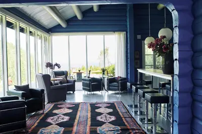 a living room with blue walls and chairs and a table at Kleivstua Hotel near Krokskogen in Sundvollen