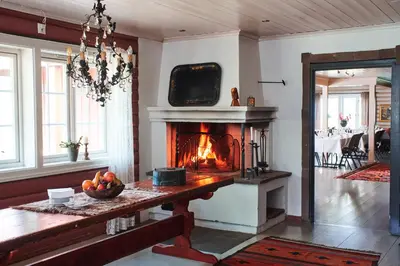 a living room with a fireplace and a television at Kleivstua Hotel near Krokskogen in Sundvollen