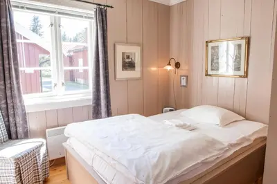 a bedroom with a white bed and a window at Kleivstua Hotel near Krokskogen in Sundvollen