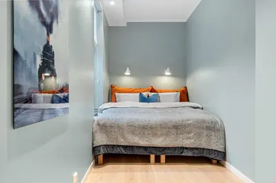a bedroom with a bed and a painting on the wall at Høyden Apartments in Bergen