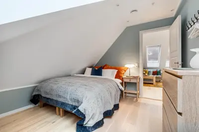 a bedroom with a bed with blue walls at Høyden Apartments in Bergen