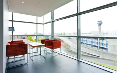a room with a table and chairs and a large window at Radisson Blu Hotel, Trondheim Airport in Stjoerdal