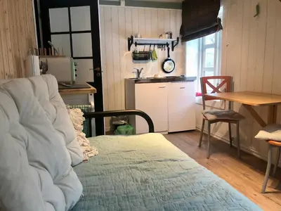 a living room with a couch and a table and a kitchen at Grønset Skysstasjon in Vinjeøra