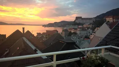 a view of a city with a sunset over the water at Penthouse with perfect location and spectacular view in Bergen