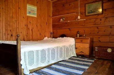 a bedroom with a bed in a wooden cabin at Kjørsvik Øvre in Tornes