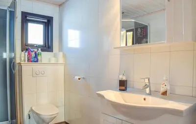 a white bathroom with a sink and a toilet at Amazing Home In Jøsenfjorden With Sauna in Gullingen