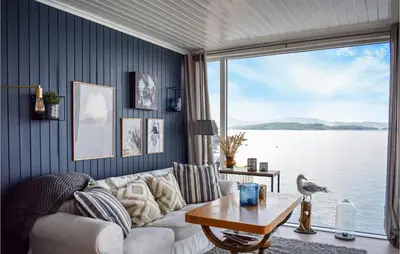 a living room with a white couch and a large window at Lovely Home In Skånevik in Skånevik