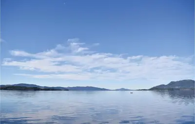 a view of a large body of water with mountains at Lovely Home In Skånevik in Skånevik
