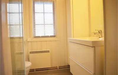 a bathroom with a sink and a toilet and a window at Four-Bedroom Holiday Home In Eggedal in Eggedal
