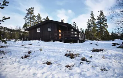 a log cabin with snow in front of it at Four-Bedroom Holiday Home In Eggedal in Eggedal