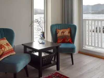 a living room with two chairs and a table and a window at 10 person holiday home in Brattvåg in Brattvåg
