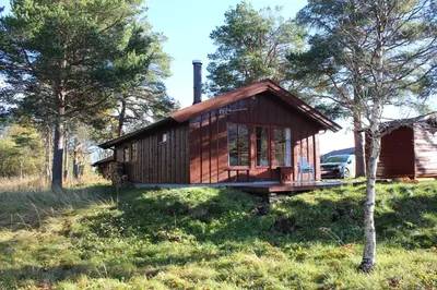 a small cabin in the woods with a car parked in front at Ådnebu by Norgesbooking - cabin with 3 bedrooms in Geilo