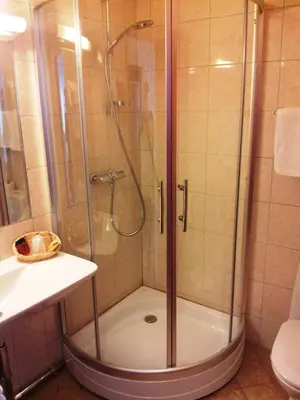 a shower with a glass door in a bathroom at Motell Nor-Kro in Bromma