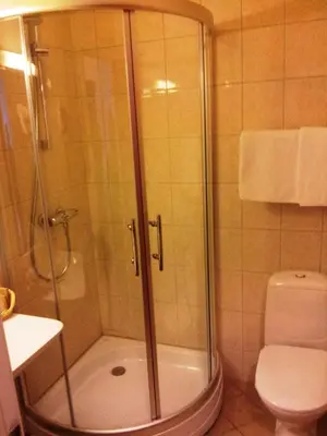 a bathroom with a shower and a toilet at Motell Nor-Kro in Bromma