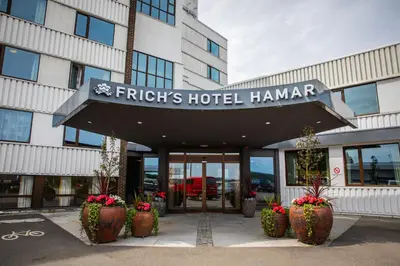 a hotel with plants in front of a building at Frichs Hotel Hamar in Hamar
