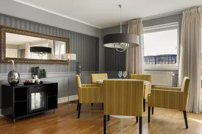 a dining room with a table and chairs and a mirror at Frichs Hotel Hamar in Hamar