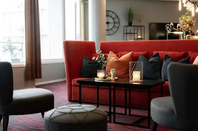 a living room with a red couch and a table at Scandic Kristiansund in Kristiansund