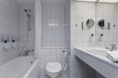 a white bathroom with a toilet and a sink at Scandic Kristiansund in Kristiansund