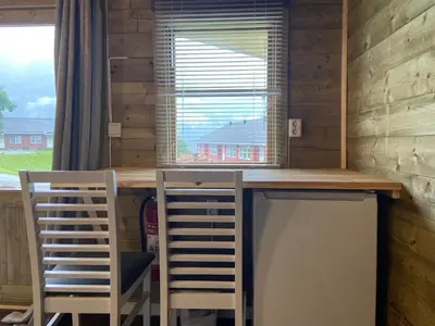 a desk in a room with two chairs and a window at Winjum Cabin Aurland Stegastein in Aurland