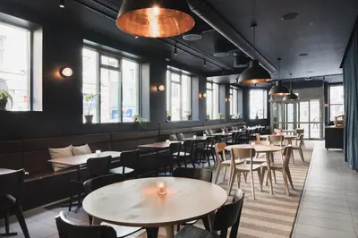 a restaurant with tables and chairs and windows at Heimen Hotel in Bergen