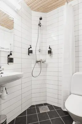 a white bathroom with a shower and a sink at Heimen Hotel in Bergen
