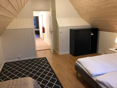 a attic bedroom with a bed and a dresser at Balestrand Fjordapartments in Balestrand