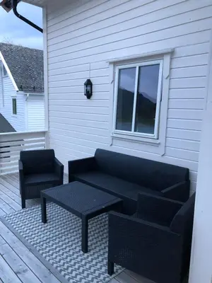 a patio with a couch and a table and a chair at Balestrand Fjordapartments in Balestrand