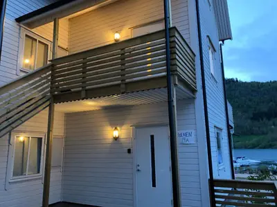 a house with a porch with lights on it at Balestrand Fjordapartments in Balestrand