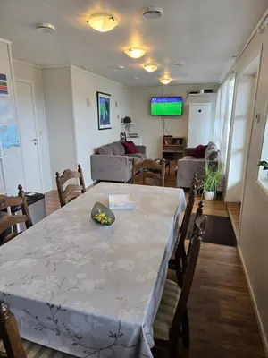 a living room with a table and a couch at Vestavind hytter og rom AS in Ålesund