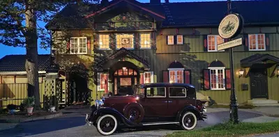 an old car parked in front of a building at Geilo Mountain Lodge in Geilo
