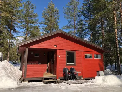a red cabin with a table and chairs in the snow at Rena Hostel IVAR in Rena