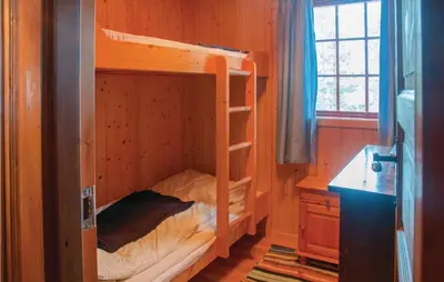 a bedroom with bunk beds in a wooden room at Four-Bedroom Holiday Home In Rendalen in Rendalen