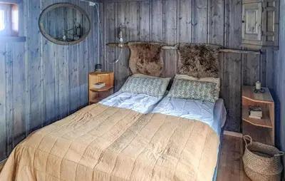 a bed in a room with wooden walls at Four-Bedroom Holiday Home In Rendalen in Rendalen