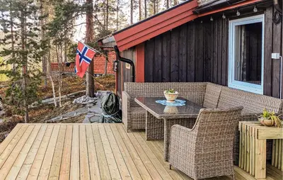 a patio with a table and chairs and a flag at Four-Bedroom Holiday Home In Rendalen in Rendalen