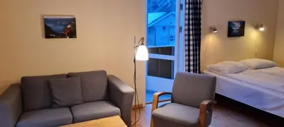 a living room with a couch and a bed and a chair at Lærdal Ferie- og Fritidspark in Lærdalsøyri