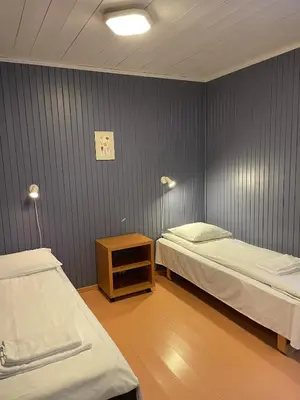 a room with two beds and a table and two lamps at Lærdal Ferie- og Fritidspark in Lærdalsøyri