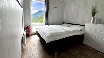 a bed in a room with a large window at Mjøsvang Kafe in Vang I Valdres