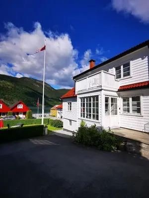 a white house with a kite in front of it at Marifjøra Sjøbuer in Marifjora