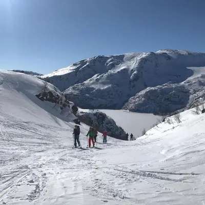 a group of people skiing down a snow covered mountain at Vatnahalsen Høyfjellshotell in Myrdal