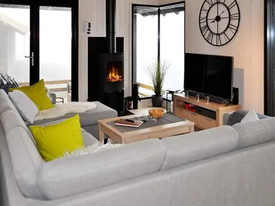 a living room with two white couches and a fireplace at 10 person holiday home in Øyer in Øyer