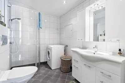 a white bathroom with a sink and a washing machine at Bergen's Best Location in Bergen
