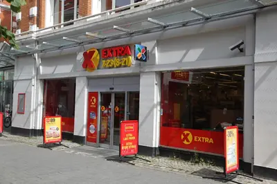 a store front with red signs in front of it at Bergen's Best Location in Bergen