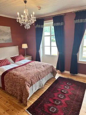 a bedroom with a bed and a chandelier at Hofslund Fjord Hotel in Sogndal