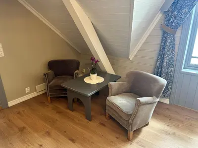 a room with two chairs and a table and a table and chairs at Hofslund Fjord Hotel in Sogndal