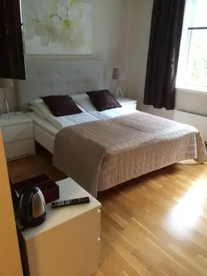 a bedroom with two beds and a table with at Nordfjord Hotell - Bryggen in Nordfjordeid