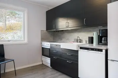 a kitchen with black and white appliances and a window at Hardangerpark AS in Kinsarvik