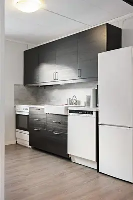 a kitchen with white appliances and black cabinets at Hardangerpark AS in Kinsarvik