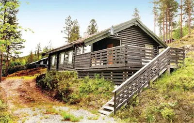 a log cabin on a hill with a wooden porch at 4 Bedroom Stunning Home In Rendalen in Rendalen