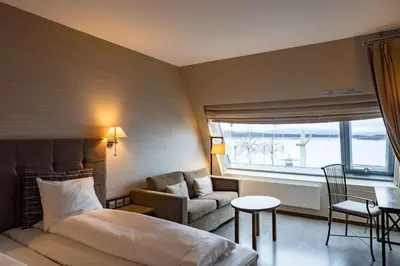 a hotel room with a bed and a couch and a window at Scandic Seilet Hotel in Molde